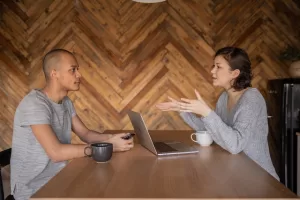 Man and woman talking over a table.