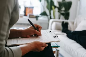 Therapist writing on notebook as a way of improving mental health